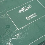 Zielone opakowanie pościeli bambusowej z białym napisem DARYmex i BAMBOO COLLECTION. Opakowanie z efektownym tłoczeniem liści bambusa. Widok z góry, pokazujący detale tekstury i logo. Brak dodatkowych elementów widocznych w tle.