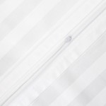 Białe poszewki z bambusowej satyny, delikatnie teksturowane z cienkimi pionowymi paskami. Zamek błyskawiczny u góry umożliwia łatwe zakładanie i zdejmowanie. Widok z bliska na detal zamka oraz wzór. Idealne jako komplet pościeli w rozmiarze 220x200 cm.