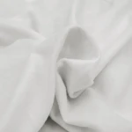 Flanelowe prześcieradło bez gumki w kolorze kremowym, z materiału o gramaturze 160 g/m², złożone w luźny sposób, ukazujące miękką, przyjemną w dotyku fakturę. Widok z góry, na jednolitym tle.