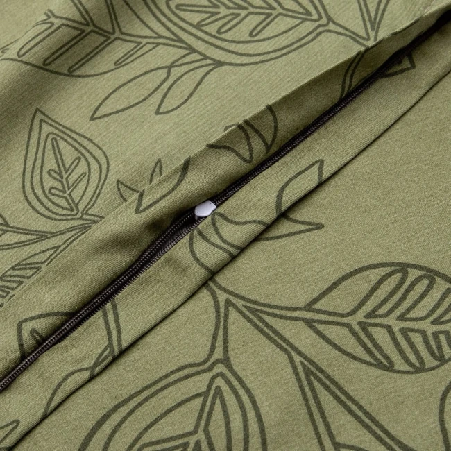 Zbliżenie na pościel satynową w kolorze zielonym z delikatnym wzorem liści. Pokazuje zamek błyskawiczny oraz teksturę materiału. Pościel leży rozłożona, ukazując detale wykończenia i wzoru, na jednolitym tle. Rozmiar 220x200 cm.
