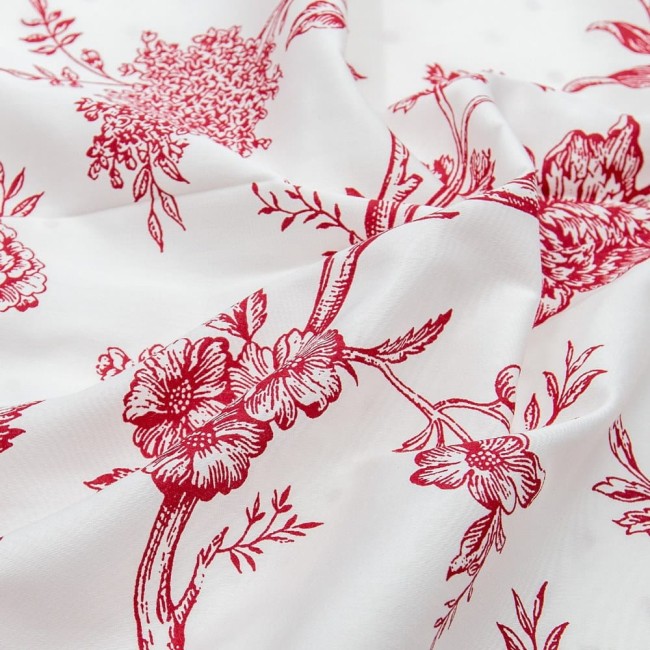 Pościel satyna bawełniana 220x200 Luxury Rose Blanc w kolorze białym z intensywnym, czerwonym wzorem florystycznym. Produkt leży na płaskiej powierzchni, prezentując szczegóły materiału i haftów. Tło jest jasne, co uwydatnia desenie.