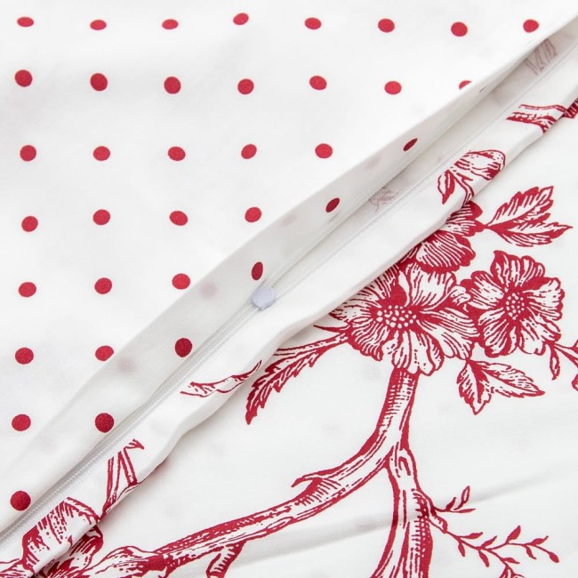 Pościel satyna bawełniana 220x200 Luxury Rose Blanc w kolorze białym z czerwonymi kropkami oraz wzorem kwiatowym. Obiekt leży na płaskiej powierzchni, z widocznym zamkiem błyskawicznym w poszewce. Tekstura materiału jest gładka.