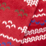 Czerwony koc bawełniany 150x200 cm z delikatnym wzorem w białe, niebieskie i zielone akcenty. Materiał o miękkiej, teksturowanej powierzchni, złożony w kształt trójkąta, ukazujący detale wzoru. Idealny na świąteczne wieczory.