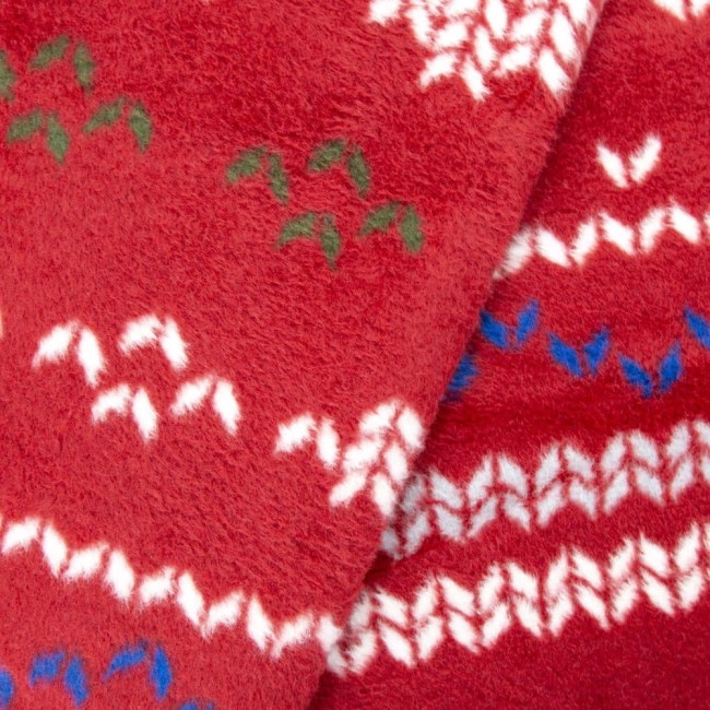 Czerwony koc bawełniany 150x200 cm z delikatnym wzorem w białe, niebieskie i zielone akcenty. Materiał o miękkiej, teksturowanej powierzchni, złożony w kształt trójkąta, ukazujący detale wzoru. Idealny na świąteczne wieczory.