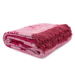 Koc bawełniany 150x200 w bordowym kolorze, z jasnym, teksturowanym wzorem oraz frędzlami na krótszym boku. Produkt złożony w trzech warstwach, widoczny z góry, na jednolitym tle. Miękki materiał idealny do użytku w sezonie świątecznym.