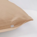 Poszewka satynowa 40x40 w jasnym beżu, leżąca na białym tle, z widocznym zamkiem błyskawicznym. Gładka faktura materiału, bez wzorów. Idealna do dekoracji poduszek w aranżacjach wnętrz.