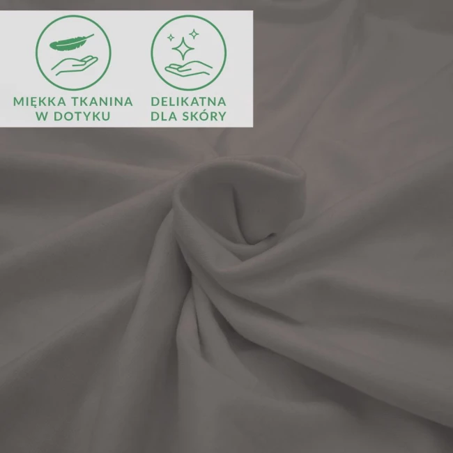 Prześcieradło jersey z elastanem w kolorze antracytowym, rozmiar 160x200 cm, z gumką. Materiał gładki, lekko rozciągliwy, z widocznymi symbolami: miękka tkanina w dotyku oraz delikatna dla skóry. Ułożone w falę, na jednolitym tle.
