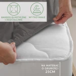 Prześcieradło jersey z elastanem w kolorze antracytowym, rozłożone na materacu o grubości 25 cm. Ujęcie pokazuje elastyczne boki prześcieradła, które idealnie dopasowuje się do materaca. Widoczne napisy informacyjne dotyczące elastyczności i trwałości.
