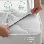 Prześcieradło jersey białe z elastanem, rozłożone na materacu o grubości 25 cm. W kadrze widoczna ręka naciągająca materiał, podkreślająca elastyczność i dopasowanie. Oznaczenia na tle informują o właściwościach, tło jasne, stonowane.
