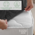 Prześcieradło jersey z elastanem w kolorze czarnym, zakładane na materac o grubości 25 cm. Produkt umieszczony na materacu, widoczne marszczenie dzięki elastycznej gumce. Ikony informacyjne dotyczące elastyczności i wytrzymałości, ujęcie z boku.