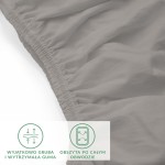 Prześcieradło jersey z elastanem w kolorze popiel szare, z gumką obszytą po całym obwodzie. Ujęcie z boku, ukazuje lekko falującą fakturę materiału. Gumka jest gruba i wytrzymała, co zapewnia stabilne mocowanie na materacu.