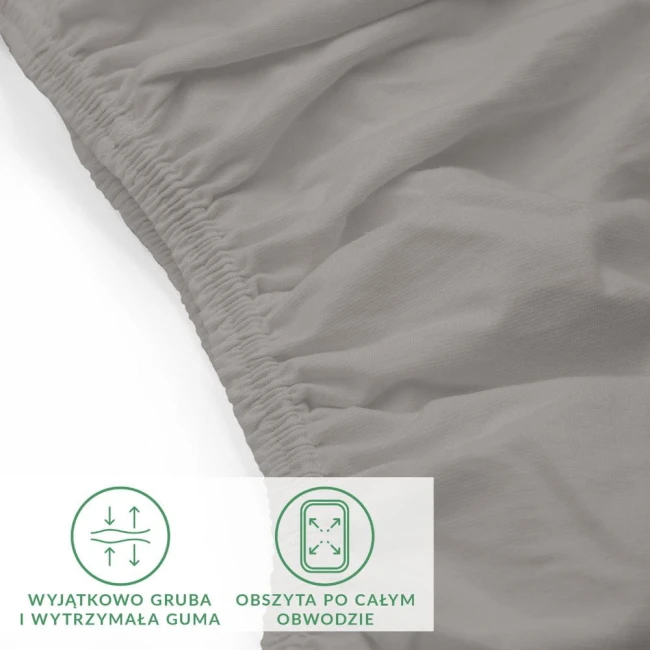 Prześcieradło jersey z elastanem w kolorze popiel. Ujęcie z boku, ukazuje gładką, elastyczną tkaninę i gumkę obwodową. Widoczna gruba struktura materiału. Dobrze dopasowane, leżące na białym tle, bez dodatkowych akcesoriów.