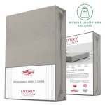 Prześcieradło jersey z elastanem w kolorze popielatym, z gumką, w rozmiarze 200x220 cm, leżące w opakowaniu. Widoczna etykieta z informacjami o producencie oraz grafika przedstawiająca zastosowanie na materacu. Tło białe.