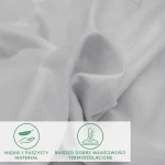 Flanelowe prześcieradło z gumką w kolorze jasno szarym, 160x200 cm, wykonane z miękkiego i puszystego materiału, widoczne z bliska, ukazuje swoją teksturę oraz właściwości termoizolacyjne. Białe tło podkreśla produkt.