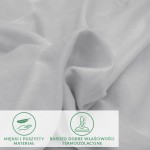 Prześcieradło flanelowe z gumką w kolorze jasnoszarym, o gramaturze 160 g/m², z bliskiego ujęcia. Materiał jest miękki i puszysty, ukazując delikatną teksturę. W tle dostępne są napisy wskazujące właściwości termoaktywne materiału.