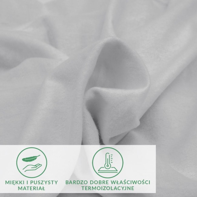 Prześcieradło flanelowe z gumką w kolorze jasnoszarym, o gramaturze 160 g/m², z bliskiego ujęcia. Materiał jest miękki i puszysty, ukazując delikatną teksturę. W tle dostępne są napisy wskazujące właściwości termoaktywne materiału.