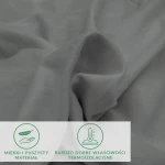 Prześcieradło flanelowe z gumką w kolorze szarym, wykonane z miękkiego i puszystego materiału, leżące na płaskiej powierzchni. Materiał ma dobre właściwości termoizolacyjne, a jego faktura jest przyjemna w dotyku. Widoczne ikony informacyjne na dole.