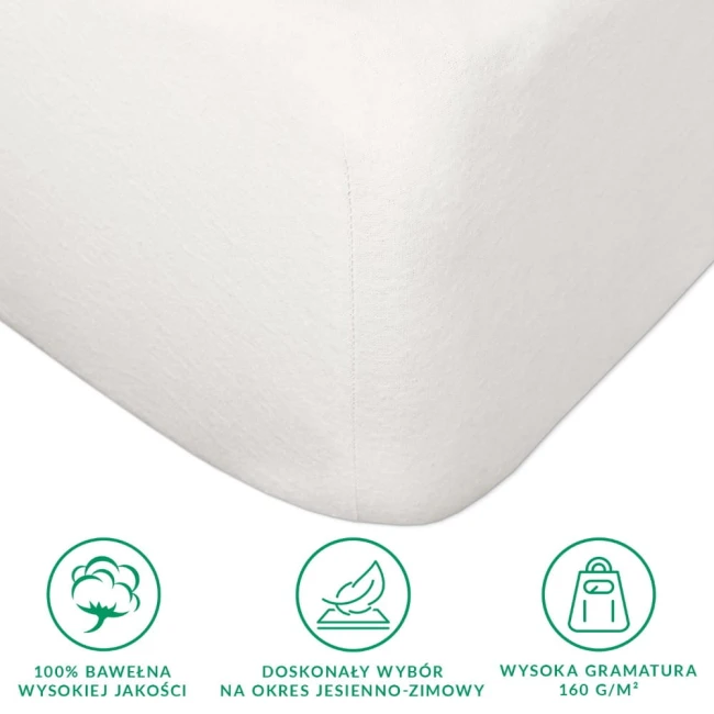 Prześcieradło flanelowe z gumką w kolorze kremowym, 180x200 cm, leżące na białym tle. Wykonane z 100% bawełny o gramaturze 160 g/m2. Widoczne wykończenie ze ściągaczem oraz subtelna tekstura materiału. Brak dodatkowych zdobień.