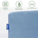 Prześcieradło jersey z gumką w kolorze błękitnym, rozmiar 60x120 cm, z widoczną metką. Ujęcie z boku, prezentujące gładką fakturę materiału, który nie wymaga prasowania i nie gniecie się. Tło jasne, skupia uwagę na produkcie.