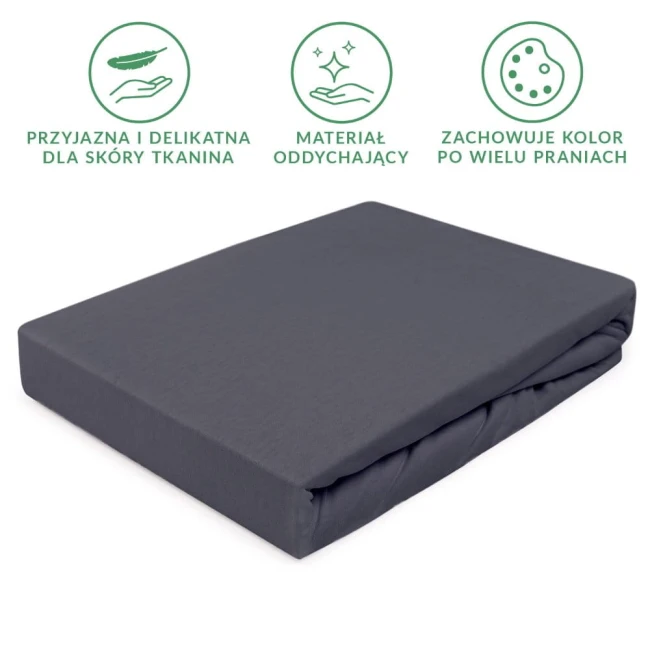 Prześcieradło jersey z gumką 200x220 w kolorze antracytowym, złożone i widoczne z boku, wykonane z delikatnej, oddychającej tkaniny. Na jednolitym tle bez dodatkowych wzorów czy napisów. Zachowuje kolor po wielu praniach.