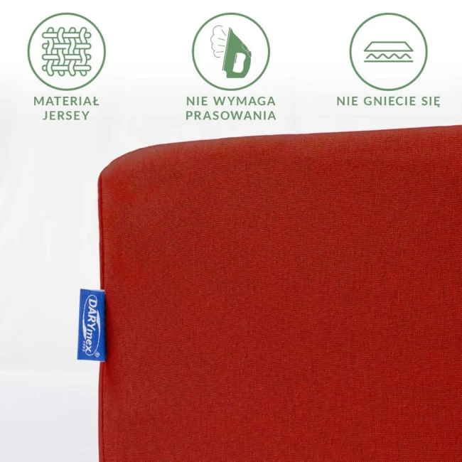 Czerwone prześcieradło jersey z gumką 180x200, widok z boku. Materiał nie wymaga prasowania i nie gniecie się, z widoczną metką. Faktura matowa, jednolity kolor. Produkt leży na białym tle, prezentując swoje właściwości.