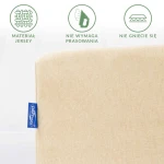 Prześcieradło jersey z gumką w jasnym beżu, leżące na białym tle. Materiał jest gładki, elastyczny, nie wymaga prasowania i jest odporny na gniecenie. Widoczna niebieska metka z logo producenta.