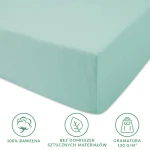Prześcieradło jersey z gumką 180x200 w jasnym turkusie, wykonane z 100% bawełny. Produkt leży na płaskiej powierzchni, ukazując naddatek materiału. Widoczne symbole dotyczące składu, ekologii i gramatury. Brak widocznych napisów lub logo.