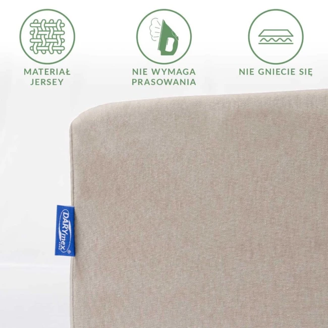 Prześcieradło jersey z gumką w kolorze kakao, z bliska ukazujące teksturę materiału. Widoczny niebieski metek. Na górze grafika podkreślająca właściwości: materiał jersey, brak potrzeby prasowania, odporność na gniecenie.