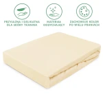 Prześcieradło jersey z gumką 60x120 w kremowym kolorze, leżące na płasko. Wykonane z przyjaznej dla skóry, oddychającej tkaniny, która zachowuje kolor po wielu praniach. Widoczne wykończenie gumki na brzegach. Brak dodatkowych elementów na tle.