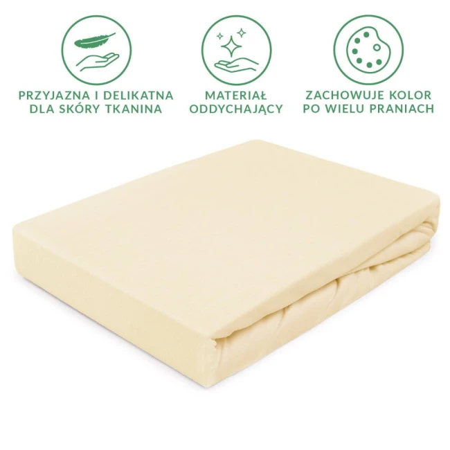 Prześcieradło jersey z gumką w kolorze kremowym, rozmiar 90x200 cm, widoczne leżące na białym tle. Tekstura materiału jest gładka i rozciągliwa, dobrze przylegająca do materaca. Produkt jest złożony, przez co nie widać detali, jak logo czy guziki.