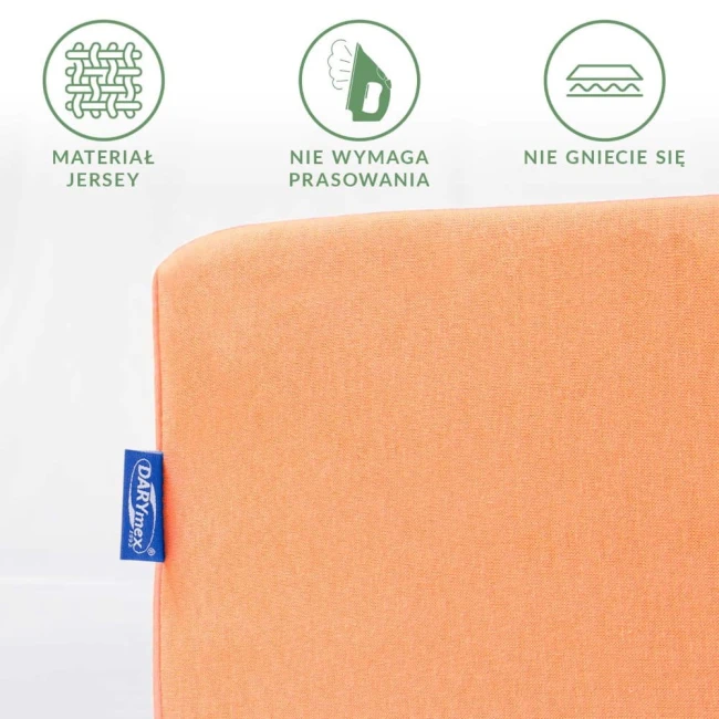 Prześcieradło jersey z gumką w kolorze łososiowym, złożone, widoczne logo w niebieskiej etykiecie. Materiał nie wymaga prasowania i nie gniecie się, co podkreślają grafiki obok. Tło proste, białe.