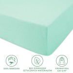 Prześcieradło jersey z gumką w kolorze morskim, leżące na białym tle. Wykonane w 100% z bawełny, z miękką teksturą. Wymiary 80x160 cm. Widoczne ikony informujące o materiale, braku domieszek i gramaturze.