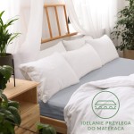 Prześcieradło jersey z gumką 160x200 w kolorze popielatym, leżące na łóżku z białymi poduszkami. Widoczna gładka faktura materiału, idealnie dopasowujące się do materaca.