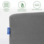 Prześcieradło jersey z gumką 120x200 w kolorze szarym, rozłożone na jednolitym tle. Zauważalne detale to logo producenta oraz informacje o materiale, braku potrzeby prasowania i odporności na gniecenie. Tekstura matowa, dobrze dopasowane krawędzie.