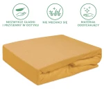 Prześcieradło frotte z gumką w kolorze musztardowym, rozmiar 90x200 cm, leży na białym tle. Produkt ma gładką, teksturowaną powierzchnię, bez widocznych napisów czy logo. Złożone z jednej strony, ukazuje gumkę, co zapewnia dopasowanie do materaca.