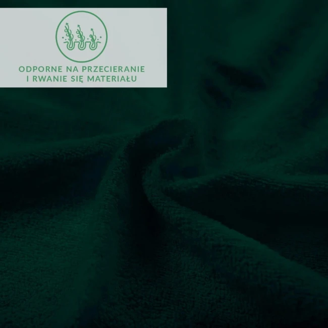 Prześcieradło frotte z gumką w kolorze zieleni butelkowej, widoczne w zbliżeniu, ukazujące teksturę materiału. Tkanina jest miękka i elastyczna, z zauważalnymi falami, co podkreśla jej właściwości.