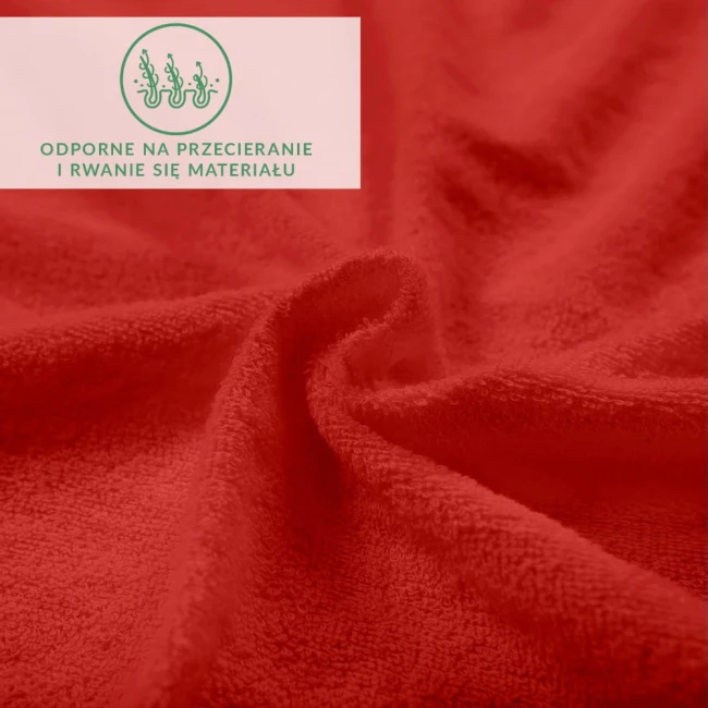 Czerwone prześcieradło frotte z gumką, widoczne z bliska, ukazuje teksturę materiału. Tło neutralne, skupiające uwagę na detalu tkaniny. Produkt elastyczny, odporny na przetarcia, idealny do łóżka o wymiarach 120x200 cm.