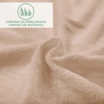 Prześcieradło frotte z gumką w kolorze beżowym, z bliskiego ujęcia, ukazujące miękką, teksturowaną powierzchnię. Materiał jest odporny na przecieranie. W tle widoczny napis informujący o trwałości materiału.