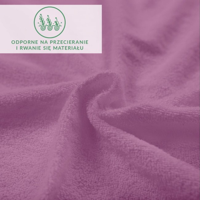 Prześcieradło frotte z gumką w jasnym fioletowym kolorze, leżące na powierzchni, z widoczną teksturą materiału. Zbliżenie ukazujące miękkość i strukturę tkaniny, z napisem informującym o odporności na przecieranie i rwanie.