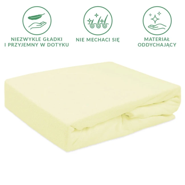 Prześcieradło frotte z gumką 140x200 w kremowym kolorze, leżące na płasko. Widać miękką, teksturowaną powierzchnię oraz gumkę zabezpieczającą, która zapobiega przesuwaniu. Tło jest jasne, co podkreśla kolor oraz fakturę materiału.