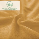 Prześcieradło frotte z gumką w kolorze musztardowym, o teksturze miękkiej i gładkiej. Widok z góry, materiał złożony w falisty kształt, z widocznymi przędzami. Logo z informacją o odporności na przecieranie umieszczone w prawym górnym rogu.
