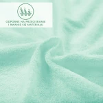 Prześcieradło frotte z gumką w kolorze błękitu morskiego, z miękką, teksturowaną powierzchnią. Uchwycone w zbliżeniu, ukazuje detal materiału i zastosowaną gumkę. Tło jest jednolite, co podkreśla kolor i fakturę prześcieradła.