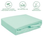 Prześcieradło frotte z gumką 160x200 w kolorze morskim, leżące na płaskiej powierzchni. Zbliżenie na miękką, teksturowaną fakturę materiału. Widoczne wykończenie gumką, zapewniające stabilne dopasowanie do materaca. Proste, jednolite tło.