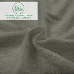 Prześcieradło frotte z gumką w kolorze szarym, wykonane z przyjemnego w dotyku materiału, prezentowane w zbliżeniu, ukazującą teksturę dzianiny. Widoczne oznaczenie dotyczące odporności na przecieranie.