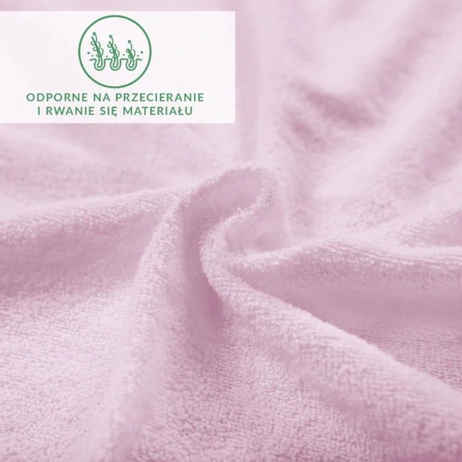 Prześcieradło frotte w kolorze wrzosowym, wykonane z materiału teksturowanego, leży na gładkiej powierzchni. Kąt ujęcia zbliżeniowy, ukazuje szczegóły tkaniny oraz odporność na przecieranie.