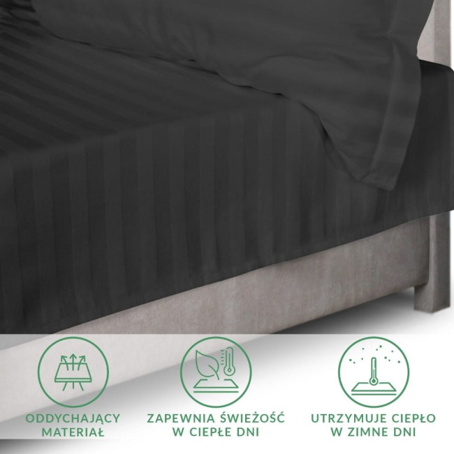 Czarne prześcieradło bambusowe satyna bawełniana 160x240 cm, rozłożone na łóżku, z poduszką w tle. Material ma subtelny wzór pasków, jest matowy.