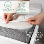 Prześcieradło satynowe z gumką 180x200 w kolorze kremowym, leżące na materacu. Widać elastyczną gumkę na brzegach, która idealnie przylega do materaca o wysokości do 20 cm. Tekstura satyny odbija światło, co podkreśla jego gładkość i elegancję.