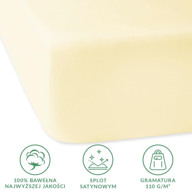 Prześcieradło satynowe z gumką 200x220 w kolorze kremowym, wykonane z 100% bawełny. Złożone, w zbliżeniu na krawędź, z wyraźnie widoczną fakturą. Na zdjęciu widoczne symbole dotyczące jakości materiału i gramatury.