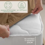 Prześcieradło jersey z elastanem w kolorze brązowym, naciągnięte na materac o grubości 25 cm, leżące na białym materacu. Widoczna gumka ułatwiająca mocowanie. W tle neutralne, jasne otoczenie. Detale materiału teksturowane i elastyczne.