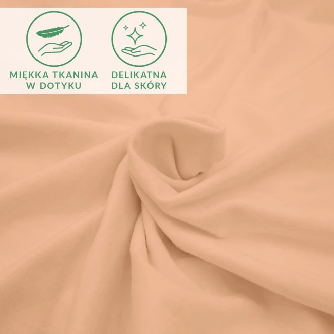 Prześcieradło jersey z elastanem w kolorze różowym, wykonane z miękkiego materiału, leżące na płaskiej powierzchni, z wyraźnymi grafikami informującymi o delikatności dla skóry. Widać fakturę tkaniny, która jest gładka i elastyczna.